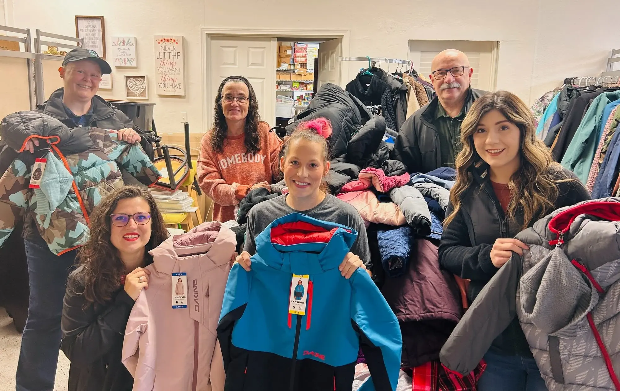 GG's House volunteers of different generations gather around winter coats collected for the community