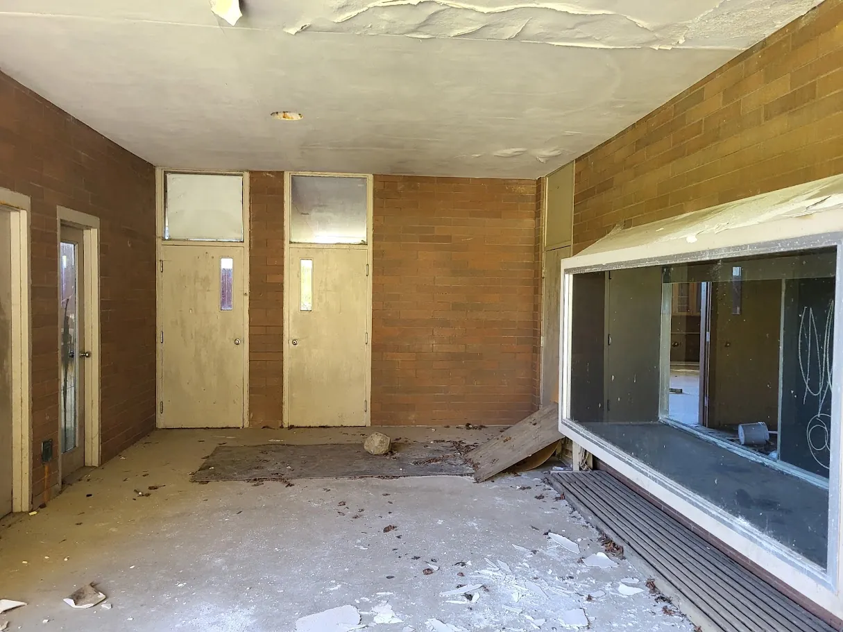 Current covered walkway showing peeling finishes and debris